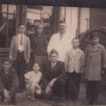 Familie în fața unui magazin cu băuturi, fotografie tip carte poștală 