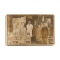 Familie în fața unei prăvălii, fotografie tip carte poștală