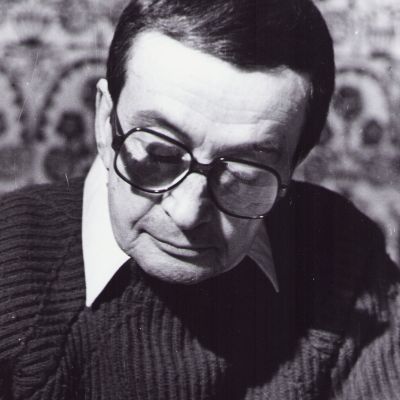 Geo Dumitrescu scriind la biroul său, fotografie realizată de Vasile Blendea, 1997